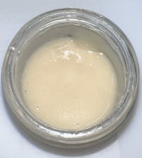 a bowl of white liquid sitting on a white surface